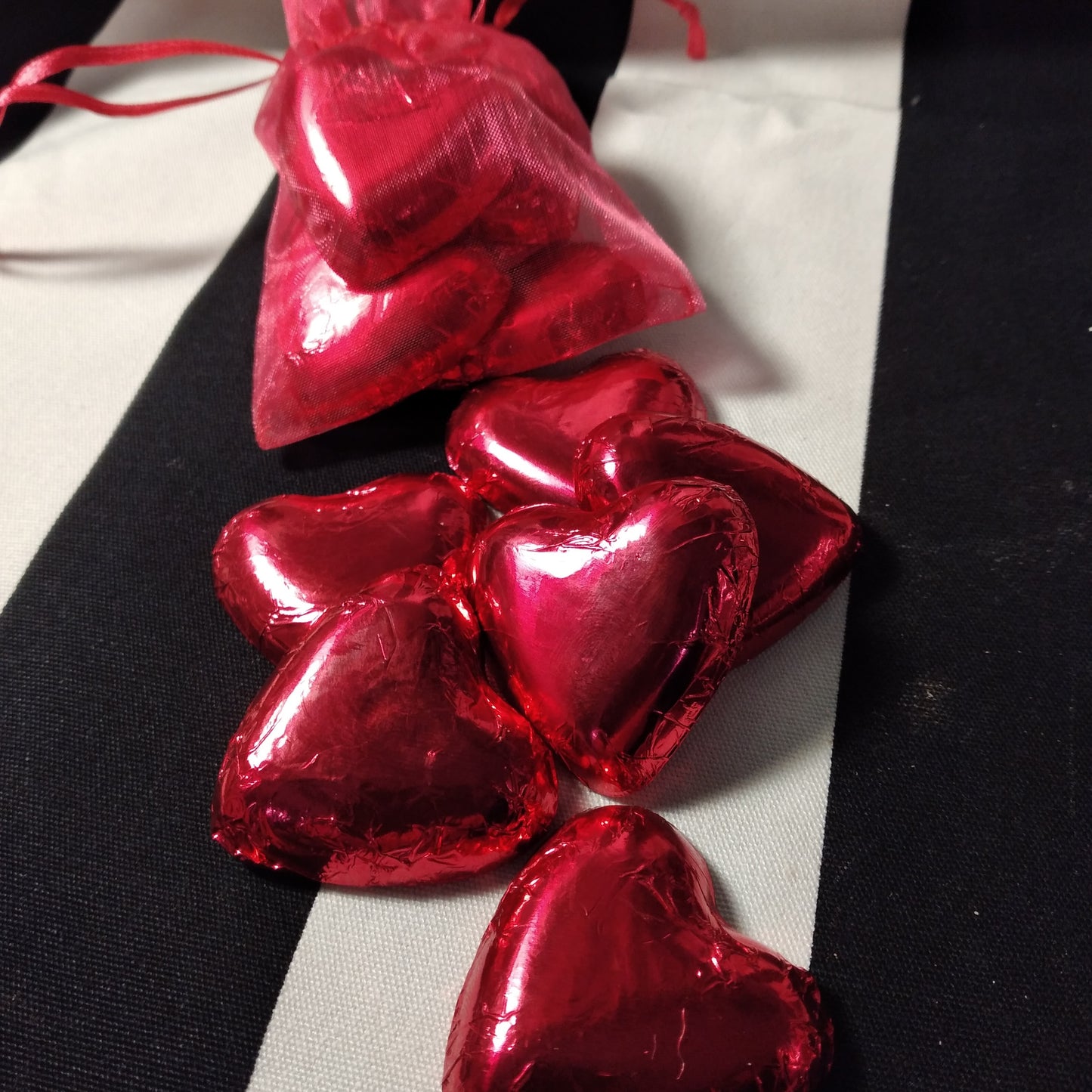 Six cœurs de Saint-Valentin en chocolat enveloppés dans une feuille végétalienne.